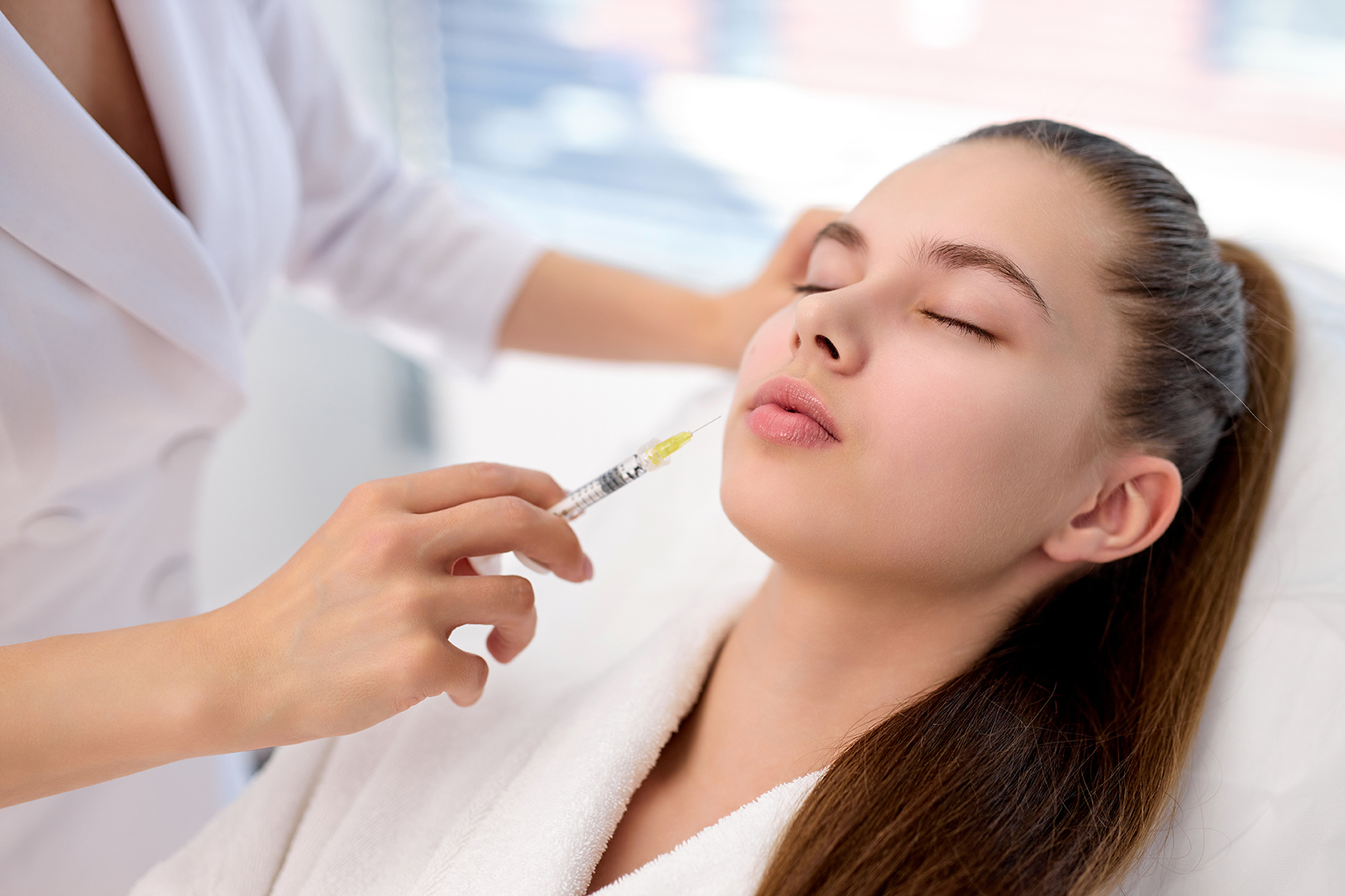 woman cosmetologist making botox injection female lips holding syringe young beautiful caucasian